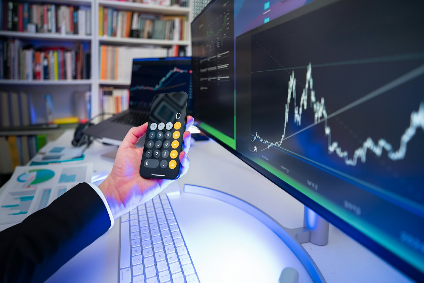 Persona analizza le finanze usando smartphone e computer.